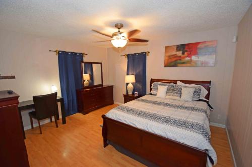 een slaapkamer met een bed en een plafondventilator bij Home Sweet Home - Peace, Love, & Enjoy in Kingsville