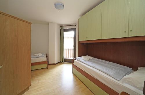 iFlat Madonna di Campiglio Alpino Orange tesisinde bir odada yatak veya yataklar