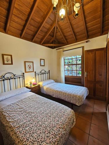 ブレーニャ・バハにあるCorral de Payo El Lagarのベッドルーム1室(ベッド2台、窓付)
