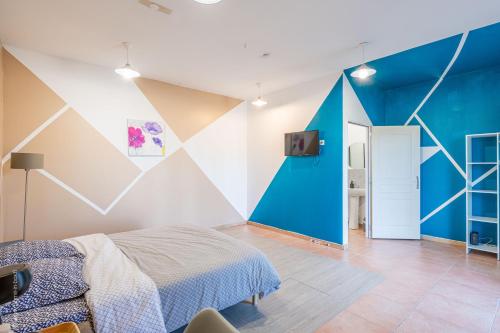 a bedroom with a blue and white wall at Logis de beauce in Boisgasson