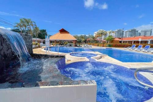 a pool with a waterfall and a swimming pool at Villa Paraíso banano 9, near to the beach & Pool in Jacó