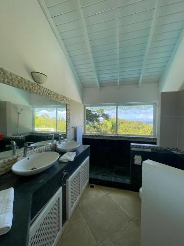 a bathroom with two sinks and a large mirror at ITAKA LOMA BONITA in Las Terrenas