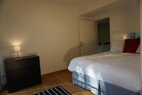a bedroom with a bed and a lamp on a dresser at Résidences Grande Jatte, Face Seine, Suites Luxe 52m2 à 97m2, Hôpital Américain à 600m in Neuilly-sur-Seine