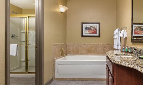ein Badezimmer mit Badewanne, Dusche und Waschbecken in der Unterkunft 2 Bedroom Deluxe Villa at the Wyndham Nashville Resort in Nashville