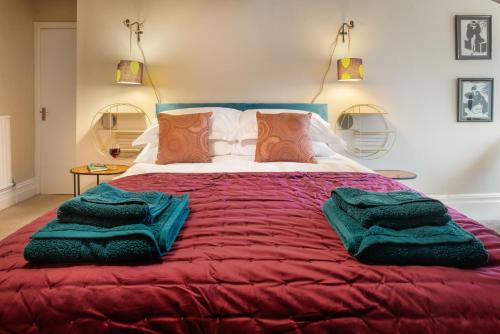 a large red bed with two green blankets on it at Albert Road Apartments Flat 3 in Colne