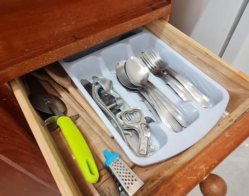 a drawer filled with utensils in a cabinet at Casa no Peró - Orla Azul in Cabo Frio