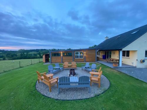 a backyard with a fire pit and chairs and a house at Sleeps 6/bus/hottub/sauna/Pets/Hens in Irvinestown