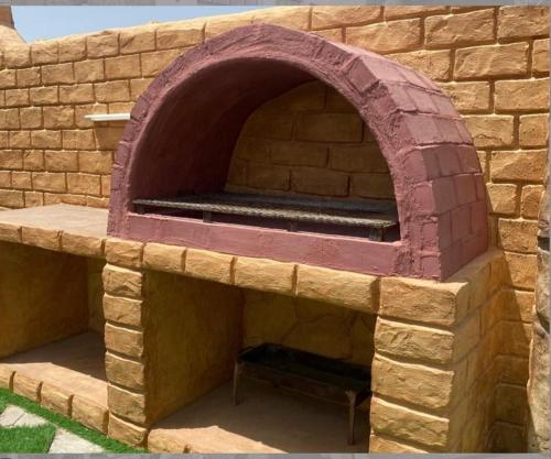 a brick oven with a bench inside of it at أستراحة السعادة in Jalan Bani Buhassan