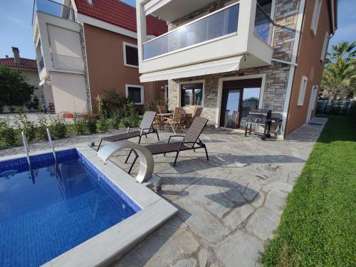 a backyard with a swimming pool and a house at VILLA CASSIOPEIA in Nikiti