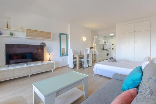 Sala de estar amplia con cama y mesa en Benal beach suite, parque acuático y vistas al mar, en Benalmádena