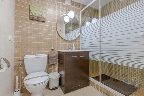 een badkamer met een toilet, een wastafel en een spiegel bij Benal beach suite, parque acuático y vistas al mar in Benalmádena