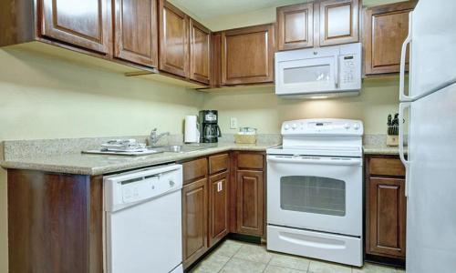 a kitchen with white appliances and wooden cabinets at Wyndham Kingsgate 2 Bedroom Deluxe in Williamsburg
