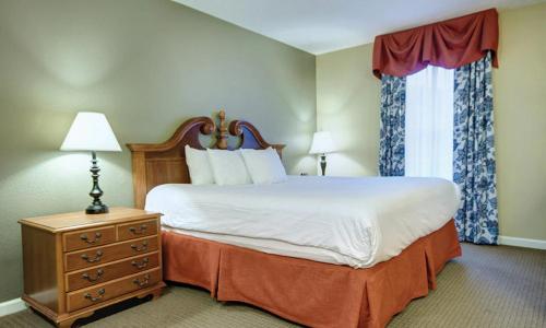 1 dormitorio con 1 cama, vestidor y ventana en Wyndham Kingsgate 2 Bedroom Deluxe, en Williamsburg