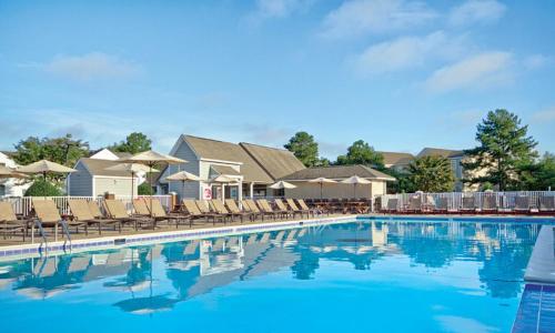 a swimming pool at a resort with lounge chairs and aominium at Wyndham Kingsgate 2 Bedroom Deluxe in Williamsburg