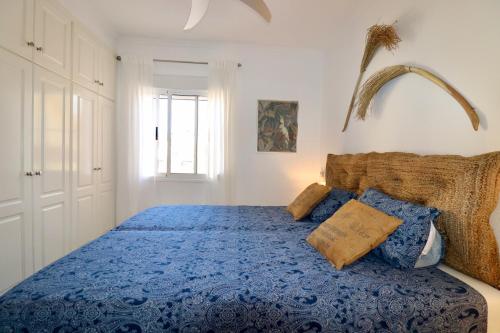 a bedroom with a blue bed with two pillows at Casa la Pajarera in Ciudad Quesada