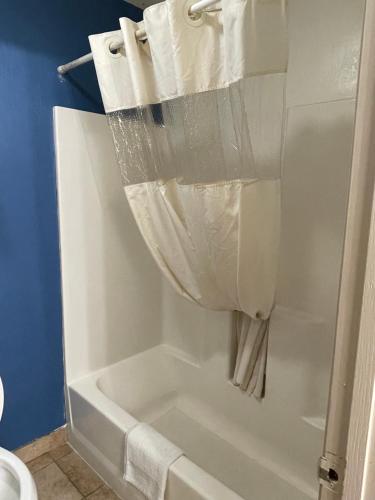 a white bath tub with a shower curtain in a bathroom at Express extended in Junction City