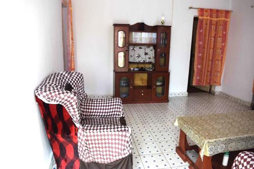una stanza con una sedia, un tavolo e un orologio di Olgosua Homestay Maasai Mara a Sekenani