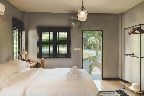 a bedroom with a large white bed and a window at Re Connect Pai - Keys Resort in Pai