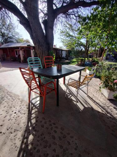 Casa La Banda في كفايات: طاولة وكراسي يجلسون تحت شجرة