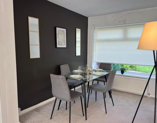 a dining room with a table and chairs and a window at Alexander Apartments Marsden in South Shields