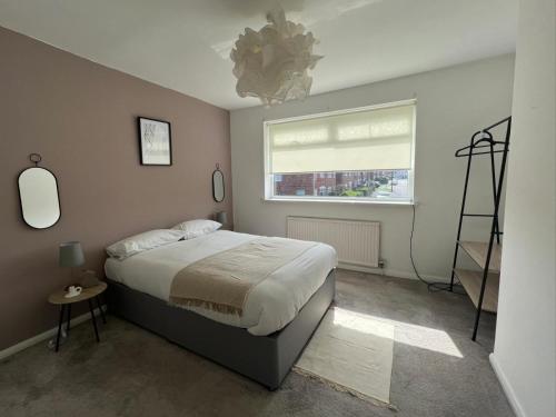 um quarto com uma cama grande e uma janela em Alexander Apartments Marsden em South Shields