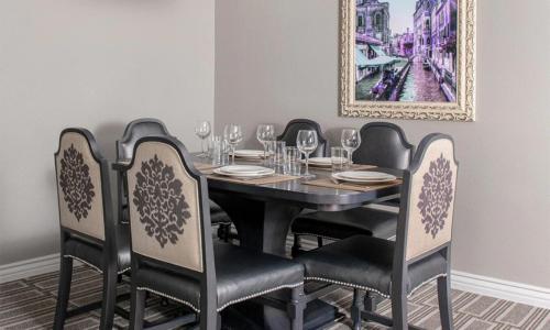 a black dining room table with chairs and a painting at Wyndham Grand Desert 2 Bedroom in Las Vegas