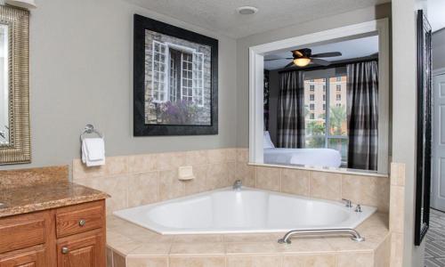 a bath tub in a bathroom with a large mirror at Wyndham Grand Desert 2 Bedroom in Las Vegas