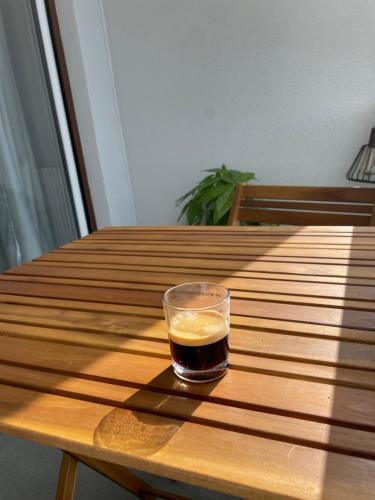 un vaso de cerveza sentado en una mesa de madera en Chaleureux appartement. Dinan, en Dinan