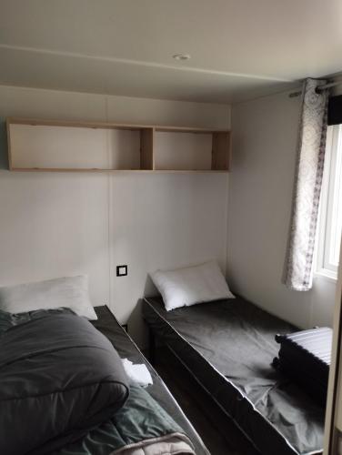 1 dormitorio con 2 camas y ventana en MOBIL HOME, en Piriac-sur-Mer