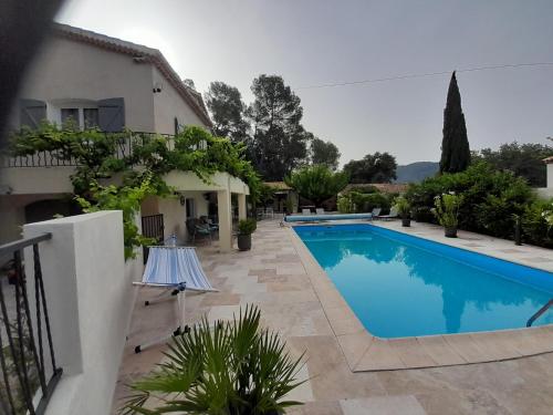 une villa avec piscine devant une maison dans l'établissement les arbousiers brignoles piscine et spa, à Brignoles