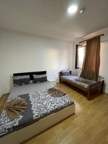 een slaapkamer met een bed en een bank erin bij Ela Hostel in Prizren
