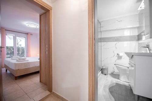 ein Bad mit einer Dusche, einem Waschbecken und einem Bett in der Unterkunft Flat with patio near Acropolis & Herodion in Athen
