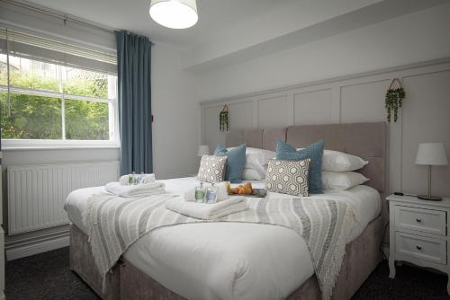a bedroom with a large bed with white and blue pillows at K Suites - Kauto Star Suite in Cheltenham