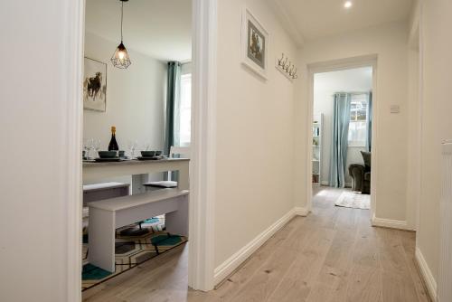 a hallway with a kitchen with white walls and wooden floors at K Suites - Kauto Star Suite in Cheltenham
