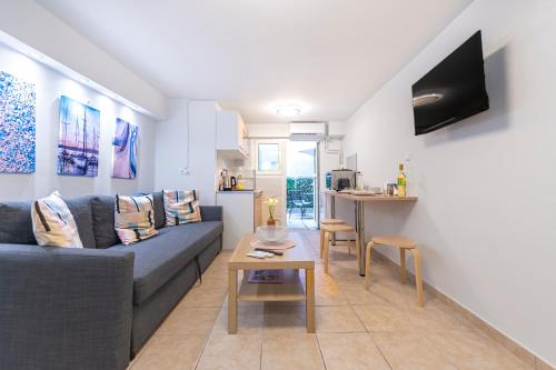 a living room with a couch and a table at Flat with patio near Acropolis & Herodion in Athens