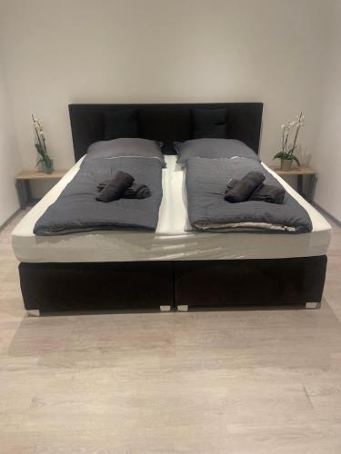 ein Bett mit zwei Kissen darauf in einem Schlafzimmer in der Unterkunft Deluxe Living Krefeld Zentrum, Nähe Düsseldorf in Krefeld