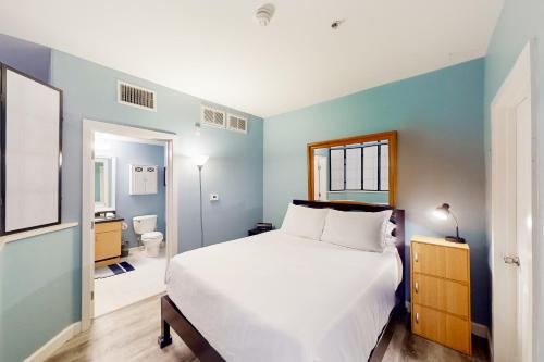 une chambre avec un lit blanc et une salle de bain dans l'établissement San Diego's Diamond: Snowbird-friendly studio near ocean with pool, hot tub, gym, balcony - dogs OK, à San Diego