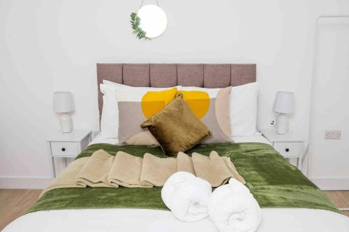 uma cama com um cobertor verde e duas toalhas em Garden of Eden 1 Bedroom Flat in Fishponds em Bristol