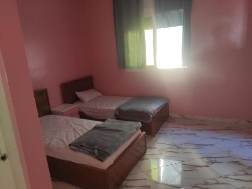 Pokój z 2 łóżkami i oknem w obiekcie Family House w mieście Kenitra