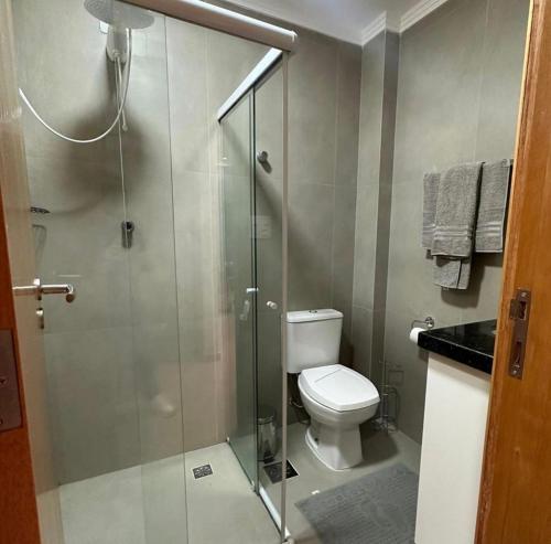 a bathroom with a toilet and a glass shower at A tranquilidade está a seu alcance. in São Vicente