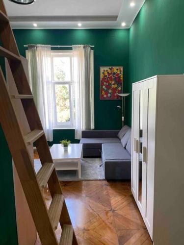 uma sala de estar verde com um sofá e uma janela em Studio 02 Apartment in Bremen em Bremen