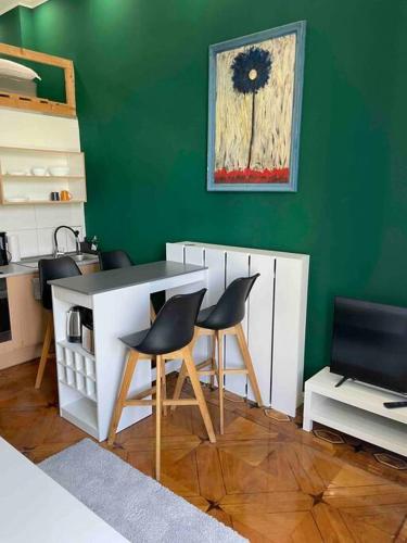 uma cozinha com uma mesa e duas cadeiras e uma parede verde em Studio 02 Apartment in Bremen em Bremen