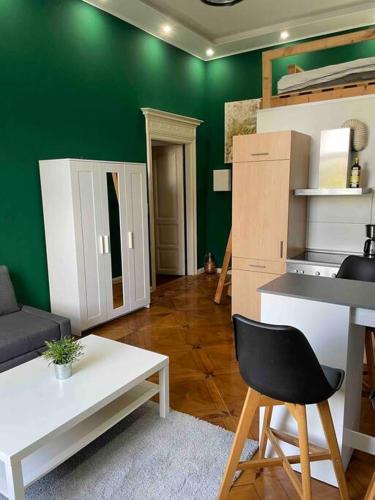 uma sala de estar com paredes verdes e uma cadeira preta em Studio 02 Apartment in Bremen em Bremen