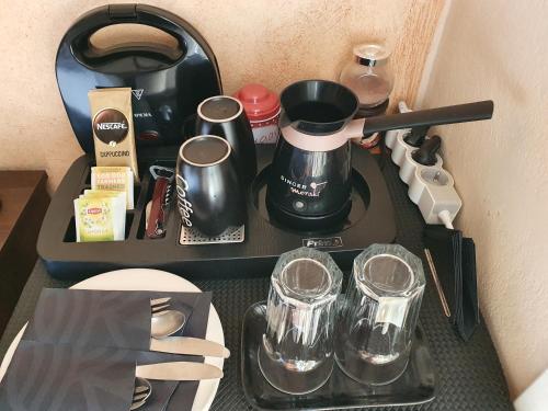 a tray with a coffee pot and glasses on it at Semeli Guesthouse in Karpenision