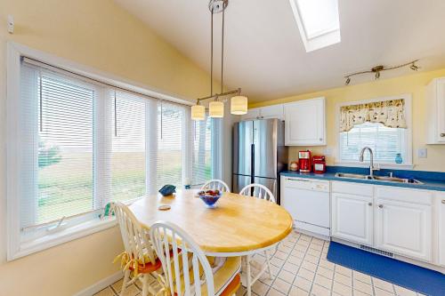 a kitchen with a wooden table and white cabinets at Bay-View Beauty in Assateague Point in Berlin