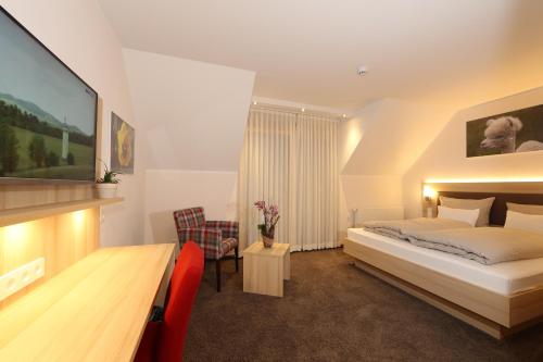 a hotel room with a bed and a table and chairs at Leidringer Gästehaus GmbH in Rosenfeld
