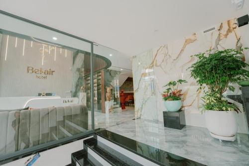 a lobby with two potted plants on the wall at Bel-Air Hotel in Quy Nhon