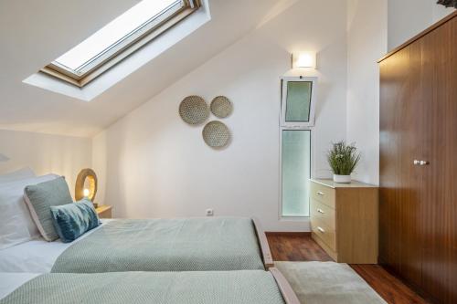 1 dormitorio con 1 cama y tragaluz en Green Valley by Madeira Sun Travel, en Porto Moniz
