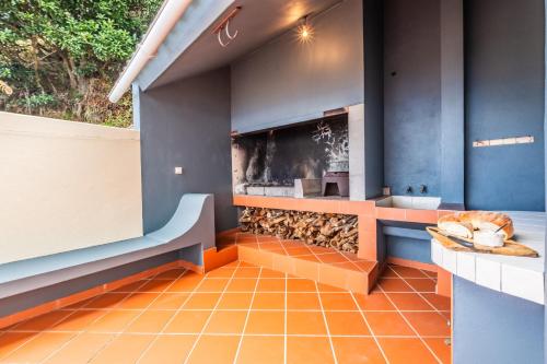 cocina con paredes azules y suelo de baldosa naranja en Green Valley by Madeira Sun Travel, en Porto Moniz