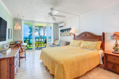 a bedroom with a bed with a yellow bedspread at "Slice of Paradise" Oceanfront Studio at Islander on the Beach 225 in Kapaa